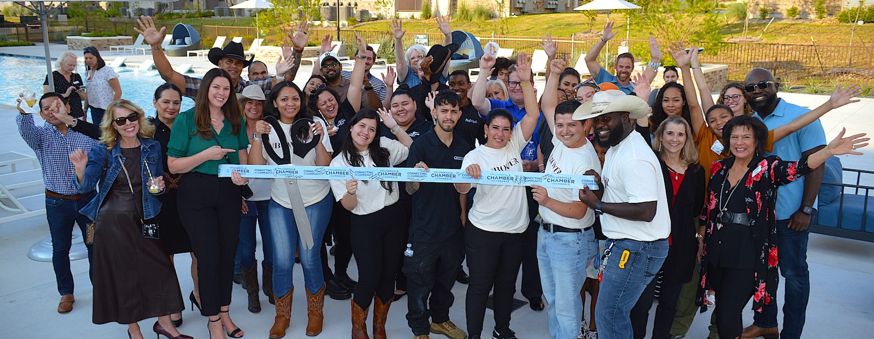 a group of people holding a ribbon and posing